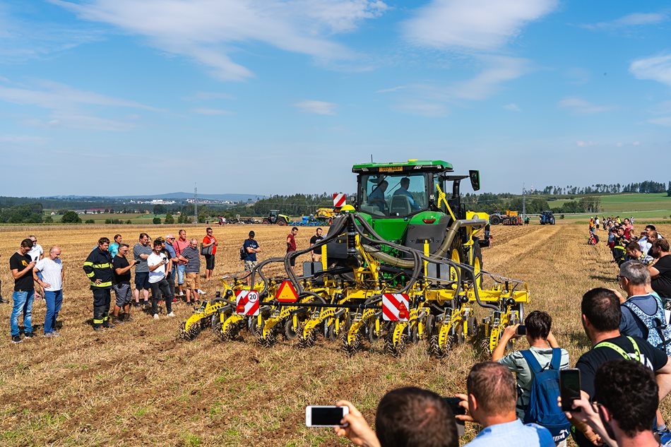 Předvádění pásového zpracování půdy v podání soupravy složené z traktoru John Deere 7R 330, čelního dvoukomorového zásobníku BEDNAR Ferti-Box FB 2000F a kypřiče StripMaster EN 6000